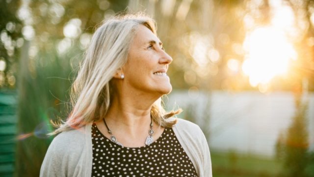 Old woman smiling at the sun.